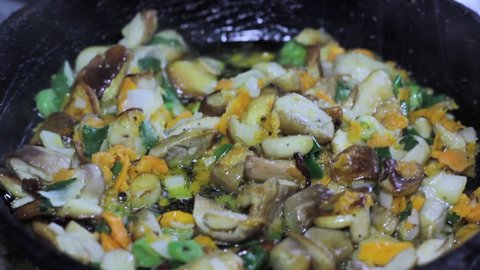 cooking mushrooms and vegetables in a frying pan