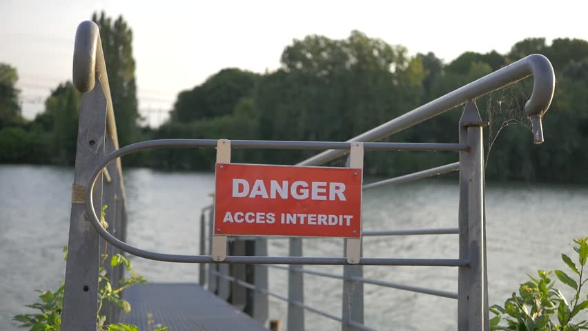 Slow motion of danger sign on the deck of a river, sunset, next to Paris France