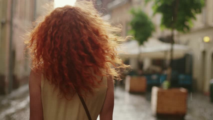 Stylish attractive woman with red curly hair walking in the rain on the street look at camera spinning happy smile cute fashion water silhouette summer face female lonely stop close up Royalty-Free Stock Footage #1013312210