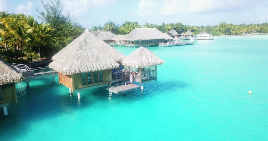 Beach travel vacation Tahiti hotel overwater bungalows luxury resort in coral reef lagoon ocean. Moorea, French Polynesia, Tahiti, South Pacific Ocean.
 Royalty-Free Stock Footage #1013317526
