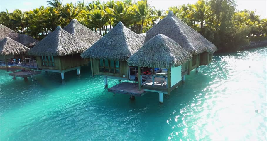 Beach travel vacation Tahiti hotel overwater bungalows luxury resort in coral reef lagoon ocean. Moorea, French Polynesia, Tahiti, South Pacific Ocean. Bora Bora
 Royalty-Free Stock Footage #1013317535