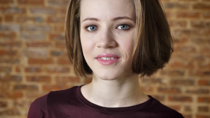 Young beautiful girl is watching down and saying wow, surprize concept, brick nackground