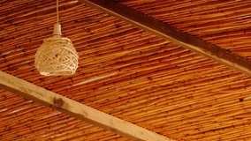 Decorating hanging wicker lantern lamp woven basket and wooden celling in interior outdoor cafe. Looping video