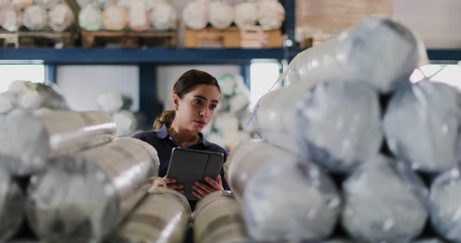 Female working in distribution warehouse with digital tablet