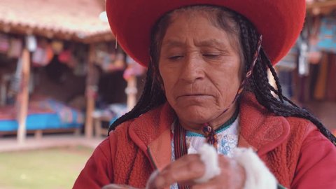 Peruvian Traditional Woman weaving alpaca wool in Peru