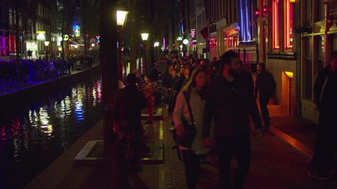Amsterdam, Netherlands - November, 2017: People walking in the Red Light District, in Amsterdam, at night.