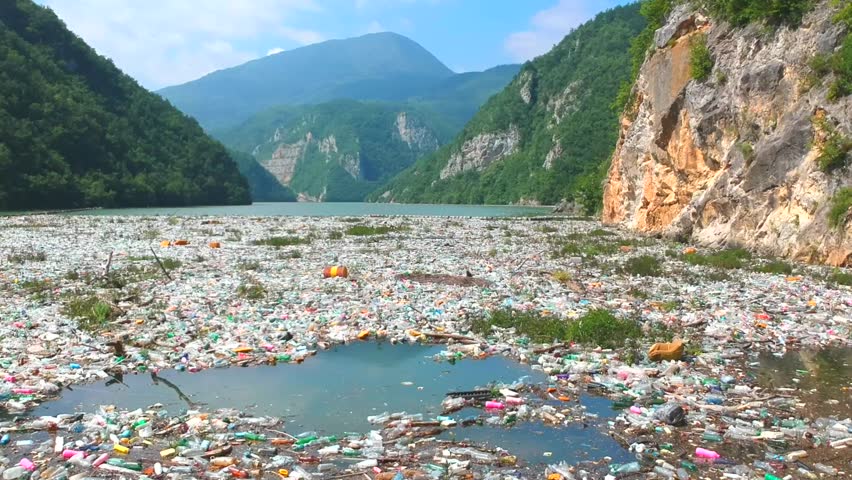 Plastic bottles in a polluted river water. Aerial view, drone view Royalty-Free Stock Footage #1013359634