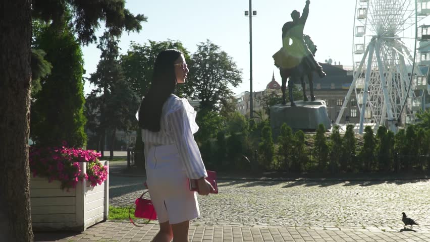 Gorgeous woman in fashionable clothes enjoy a silence in morning summer park