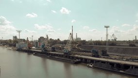 Moving cranes in harbor in Wroclaw, Poland. Odra river, industrial, factory, crane / 4K Drone Video