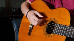 Girl hands strumming an acoustic guitar.