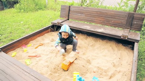 A child in the kindergarten playing in the sandpit HD 1920x1080