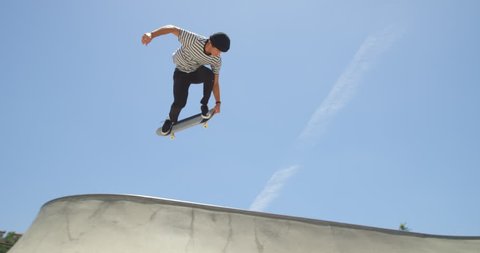 Skateboarder does extreme air off ramp isolated in sky on sunny day 