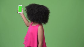 Young cute African girl with Afro hair showing phone and pointing finger