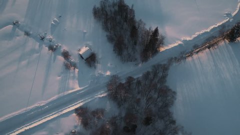 Aerial flight over Swedens snow covered countryside, revealing beautiful sunset in 4k.