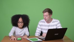 Young African girl and young Scandinavian man using gadgets together
