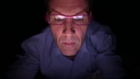 Mature Scandinavian man watching adult videos with digital tablet in dark room