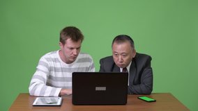 Mature Japanese businessman and young Scandinavian businessman working together