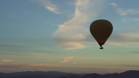 aerial view of hot air balloon over the desert and mountains during sunrise outside of Marrakech, Mororcco.