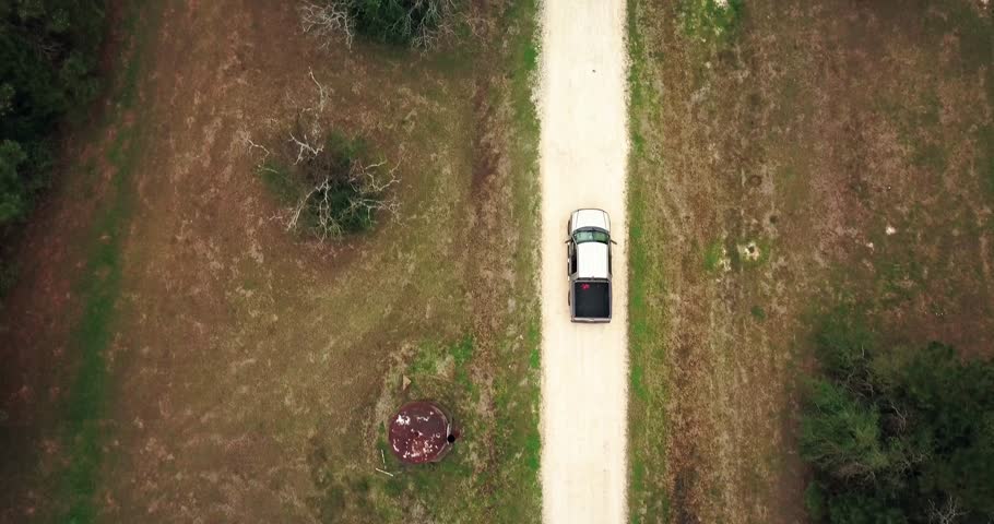 Aerial Chase of Tan Ford F150 Pickup on gravel road 150 feet directely over the truck.