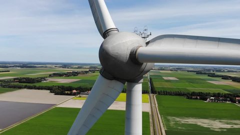 Aerial close up shot of a turning wind mill or wind turbine generating clean green and environmentally friendly energy and electricity