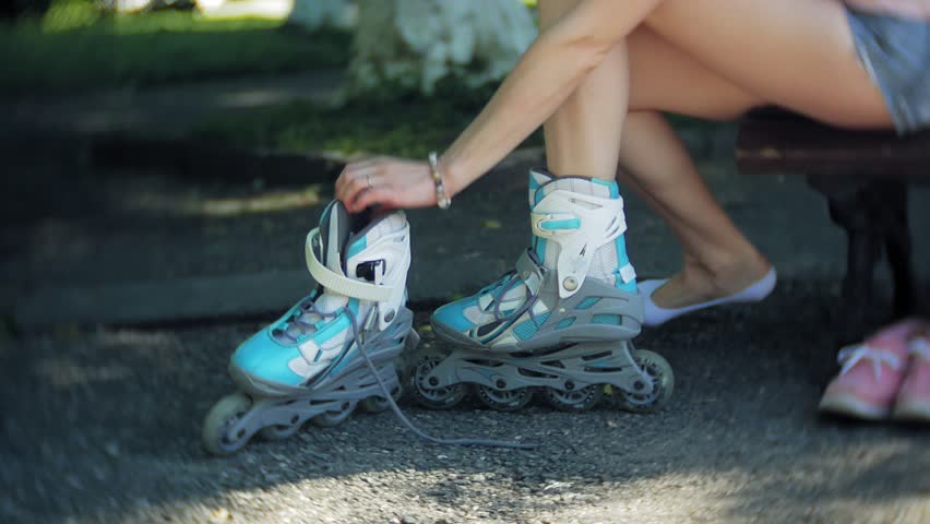 woman dresses roller skates sitting on bench in park 4k
