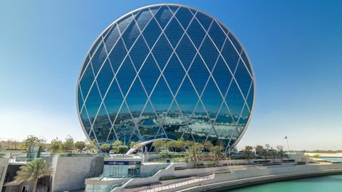 ABU DHABI, UAE - CIRCA MARCH 2018: Circular skyscraper Aldar Headquarters Building timelapse hyperlapse in Abu Dhabi, UAE. View from bridge. It is the first circular building of its kind in the Middle