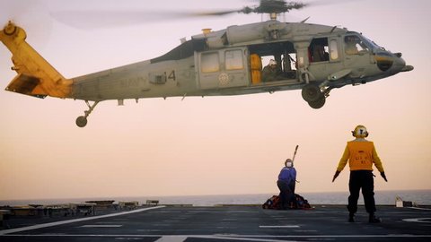 CIRCA 2017 - A US Navy helicopter hovers over the landing area of the USS Gabrielle Giffords.