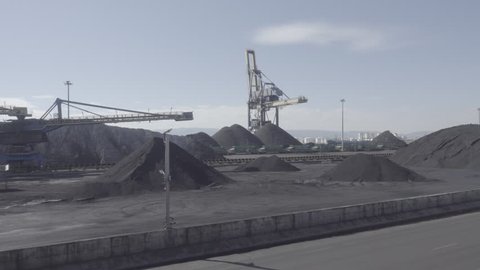 Large Stockpiles of Coal and a big charging crane in Tarragona port terminal.Air pollution from coal-fired power plants is linked with severe environmental and public health impacts.
