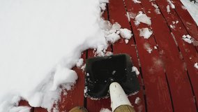 Flagstaff AZ/USA - January 15, 2018: Shovel cam point of view of shoveling snow off a wood deck. Clip provides an unique perspective to a normal winter task or chore.