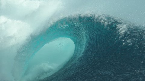 SLOW MOTION, CLOSE UP: Forceful barrel wave splashes beautiful crystal clear water everywhere around the sunny coast of Tahiti. Amazing shot of a large tube wave right when it breaks and crashes.