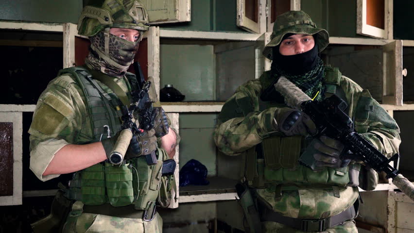 Two soldiers in full gear reloading weapons