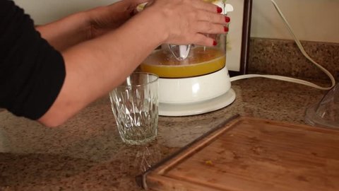 Pouring orange juice in a small crystal glass