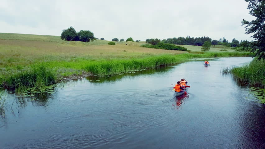 Canoes drifting down a quiet stream, through trees and fields, under old bridges, through the beautiful Danish countryside.