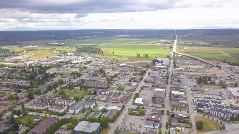 Arcing Aerial Drone Wide Angle View of Cloverdale, Surrey, BC, Canada. The Entire Downtown Area Can be Seen From Above Along with Fields and Farms in the Background