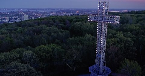 AERIAL: Flying over the cross structure in a forest at night on Mont Royal, Montreal
