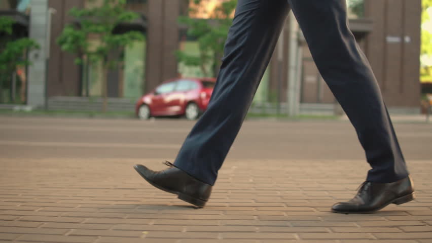 man wering blue trousers walks confident. his shoes are black and shiny. Royalty-Free Stock Footage #1013459909