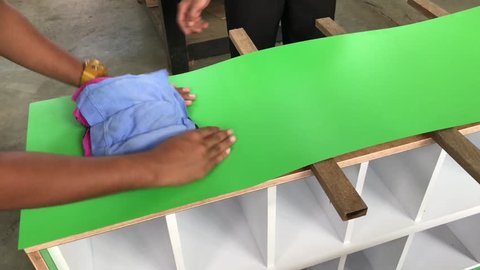 Cabinet makers applying formica to build shoe rack closets