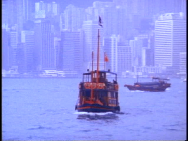HONG KONG, 1982, medium shot of harbor, misty and gray, boat moves across
