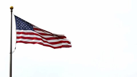 High definition 1080p video of American flag flying high on a pole against white sky background on a clear windy day 1920x1080