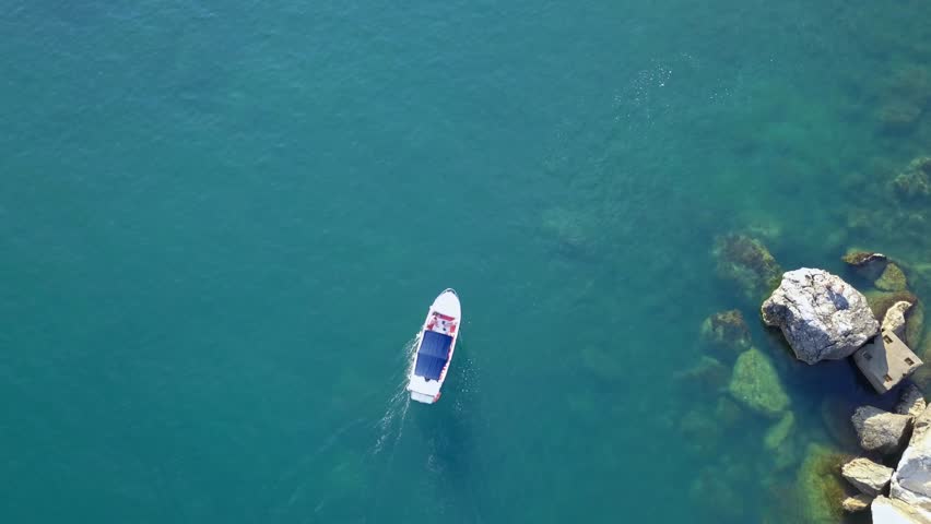 aerial flying shot of fast motor boat near the sea coast bay