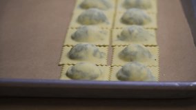 This video shows the process of cooking Ravioli. This clip shows the Ravioli on a tray ready to be separated and cooked.