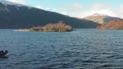 Small Boat Scottish Loch, small outboard engine, Winter/Autumn Snow on Mountains