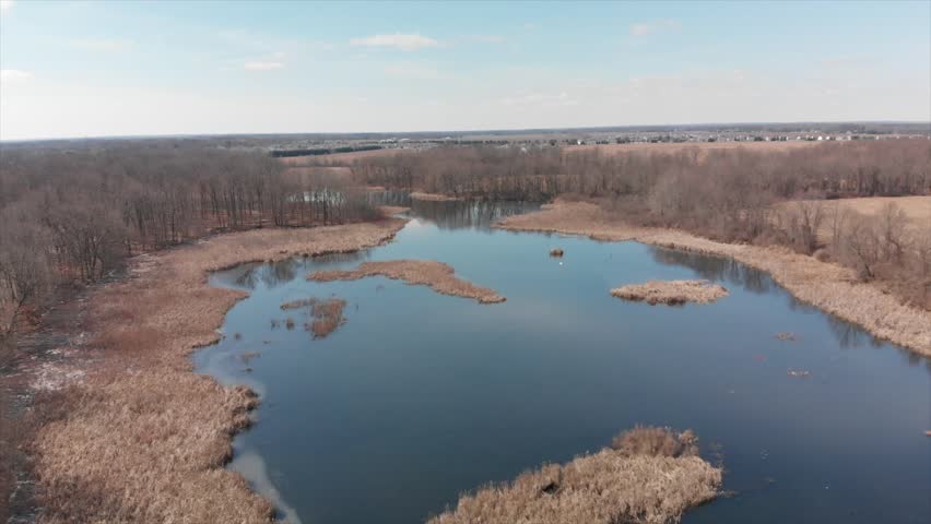 Melting ice, and early spring lakes and trees in Michigan. Pontoons, and greenery.