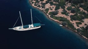 View from above of beautiful sailboat without people and deserted beach with many bushes, spoty shoreand torquoise water, Turkey island