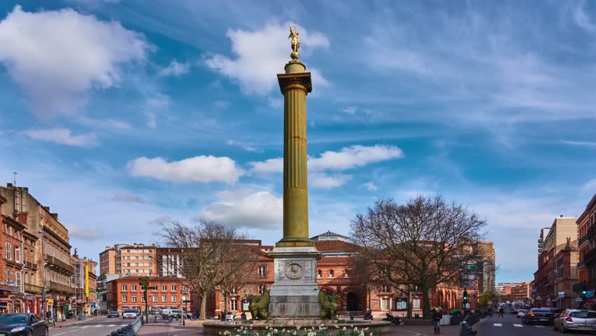 Dupuy column and in background Halle aux Grains. Fountain with griffins on Dupuy Square near National Orchestra of Capitol in Toulouse, France.