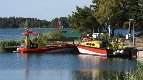 Okno, Monsteras, Sweden - June 28, 2018: Everyday scene of two search and rescue boats moored in a marina surrounded by coastal nature landscape. Late summer afternoon.