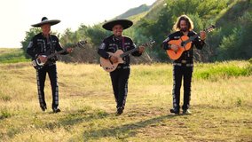Mexican musicians mariachi band plays guitar and sing at sunset in the mountains. 4K video