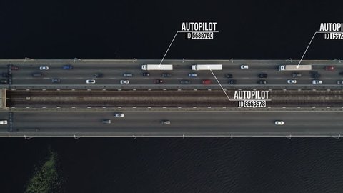 Aerial shot of autonomous (driverless, self driving) container trucks on highway bridge over river