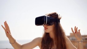 Portrait of girl wearing VR glasses and enjoying virtual worlds. Close up. Future is right now. Google cardboard. Beautiful young woman playing game in virtual reality glasses. Slow motion 120 fps