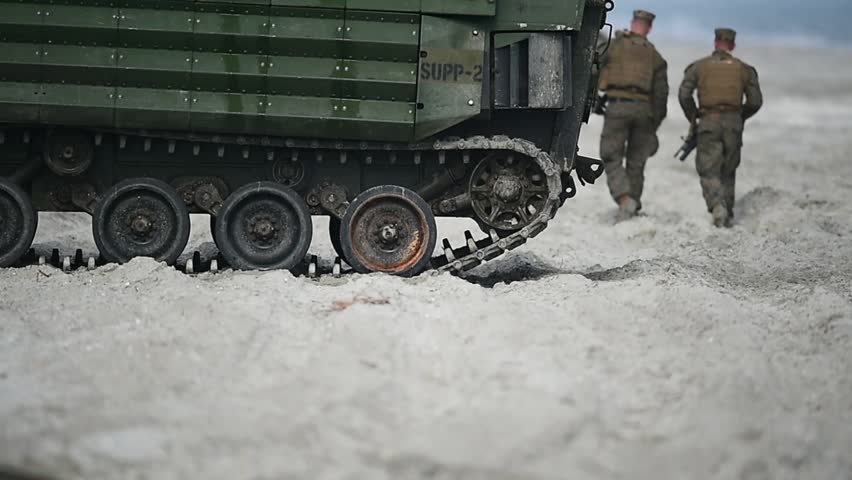 Amphibious tank caterpillars are seen on a beach in the sand
